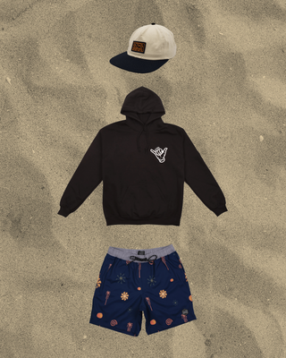 Black AQWA hoodie, navy tropical shorts, and beige cap. Perfect for relaxed beach outings and cool evening walks.