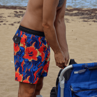AQWA floral print boardshorts in red, yellow, and blue tones, perfect for a bold beach look.