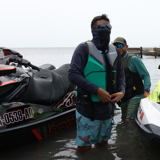 AQWA long sleeve rash guard under life vest, worn during jet ski ride — built for sun protection, speed, and aquatic performance.