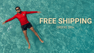 Man floating in crystal-clear Caribbean water wearing a red AQWA performance rash guard and black swim shorts — tropical lifestyle apparel for beach, boat days, swimming, and sun protection in Puerto Rico.