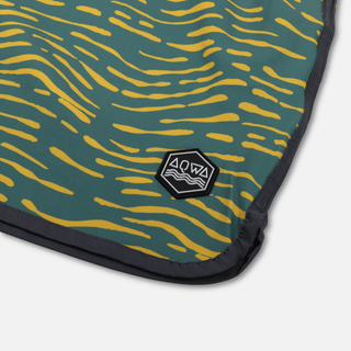 Close-up of AQWA hexagon logo on corner of swim trunks – premium stitching and textured patch.