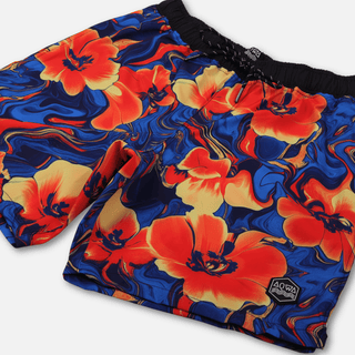 Angled view of AQWA floral swim trunks showing fit, front pocket detail, and curved silhouette – ready for land and sea.
